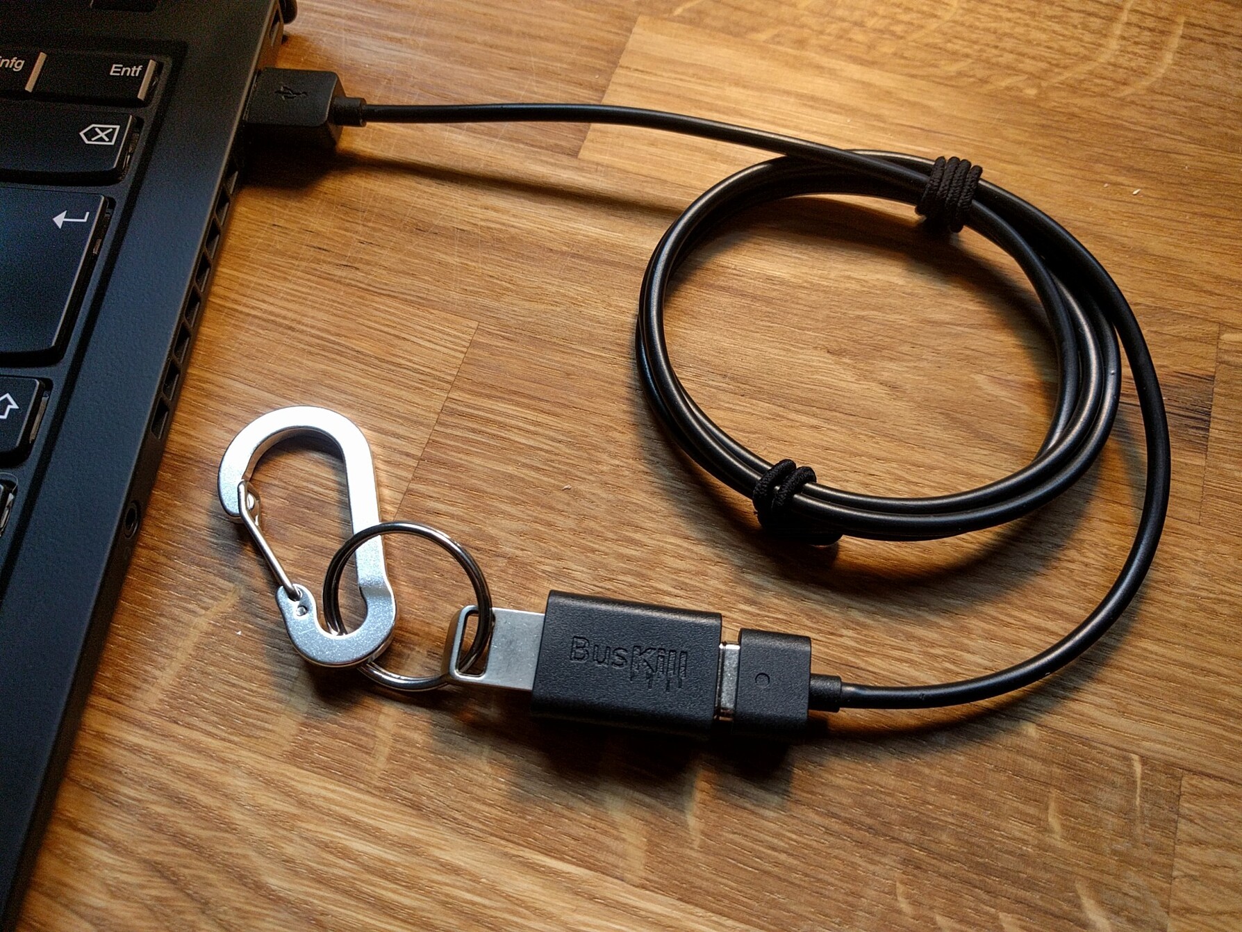 picture showing the fully-assembled BusKill cable with the USB Storage Drive connected to the magnetic breakaway connected to a laptop's USB port